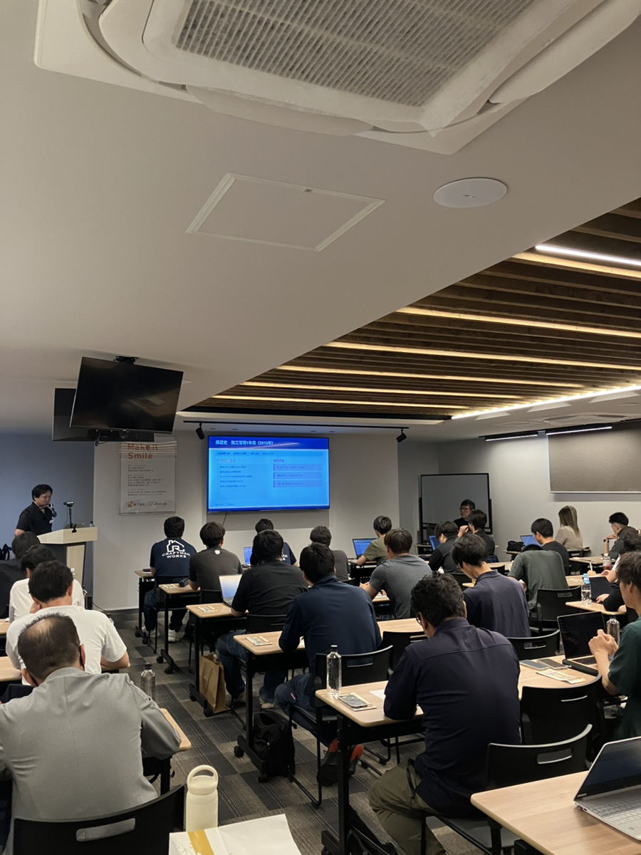 6月の勉強会の会場。参加者が机に向かい、前のスクリーンを見ている